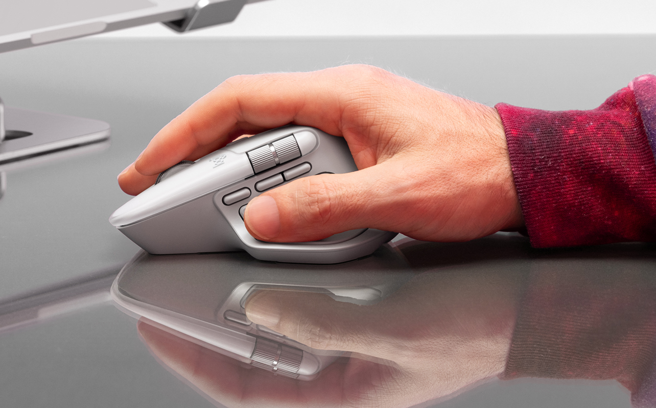 Man's right hand holding onto Ligtech MX Master 4 mouse