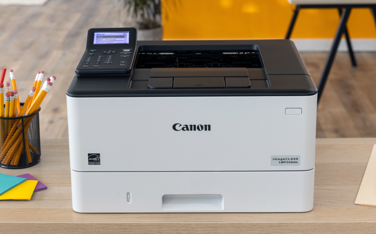 Laser printer sitting on top of a desk at home.