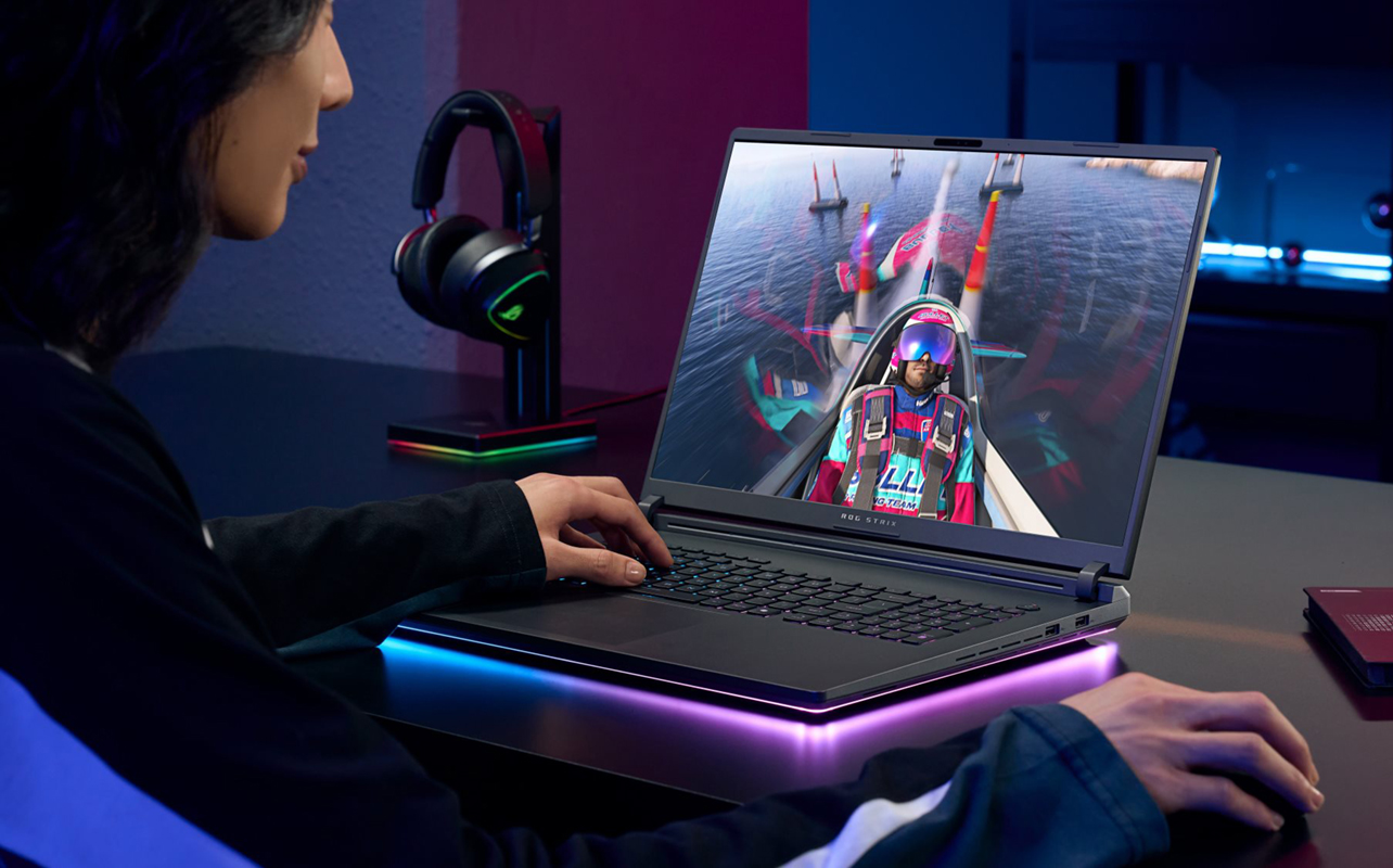 Woman playing video games on a gaming laptop.