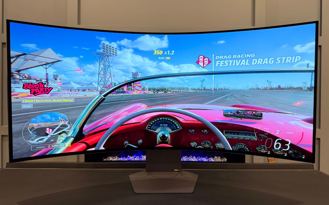 An ultrawide LG monitor with an oen top red car.