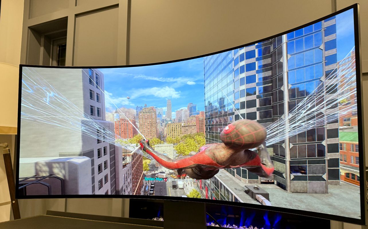 Spider-Man swings through a city on a curved LG UltraGear 5K2K display.