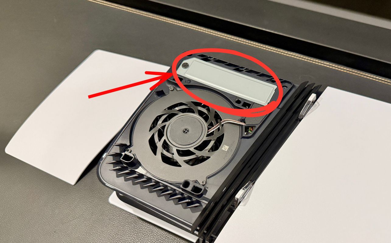 A picture with red lines indicating the steps to remove the SSD cover to access an installation.