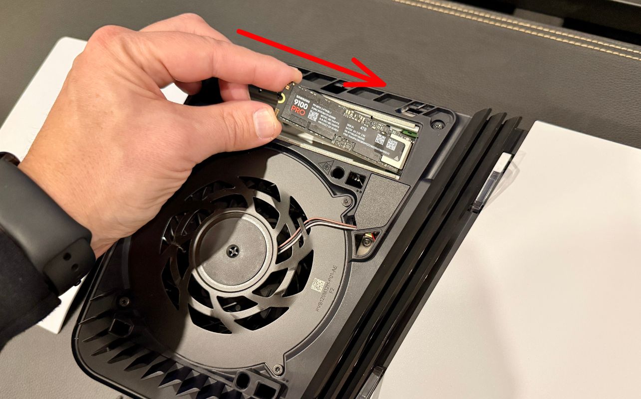 An SSD getting installed into the PS5 Pro console.