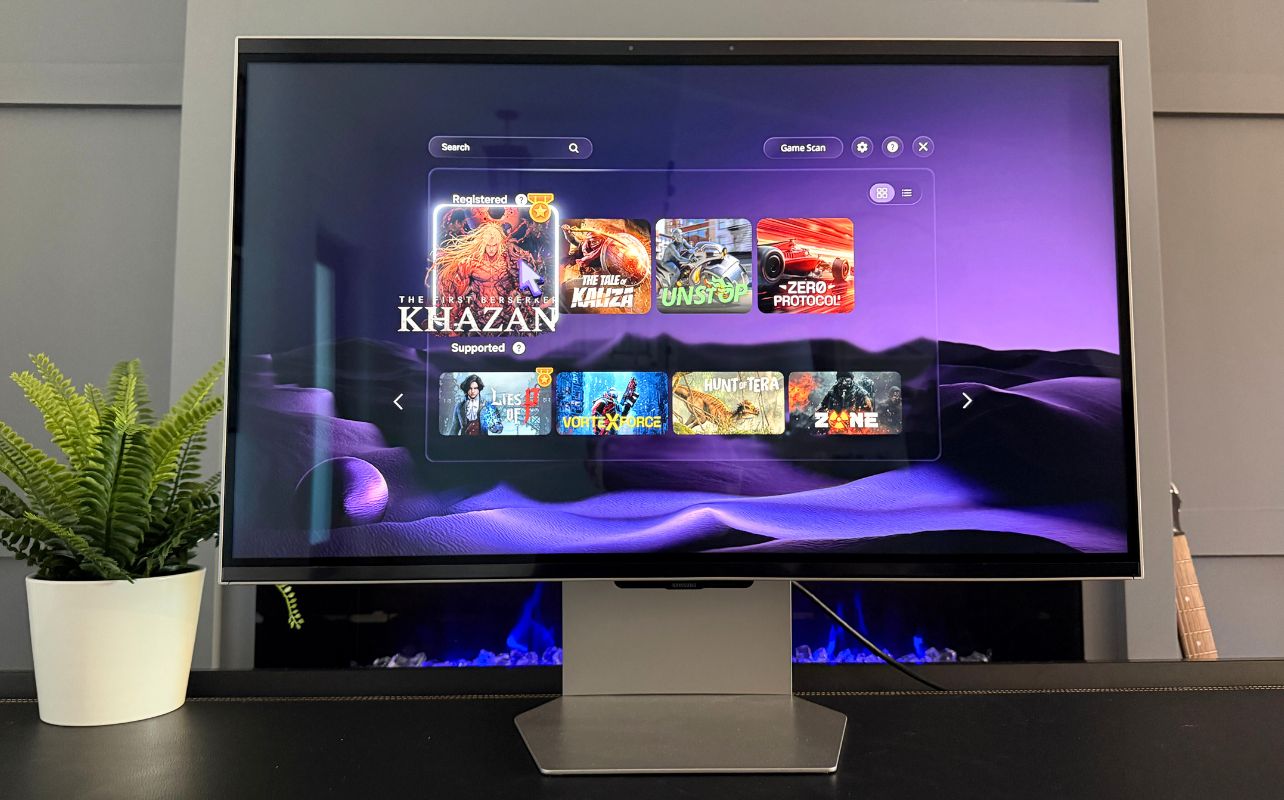 Samsung Odyssey 3D monitor displays a game library on a purple wavy background. Titles include "KHZAN" and "ZERO PROTOCOL."