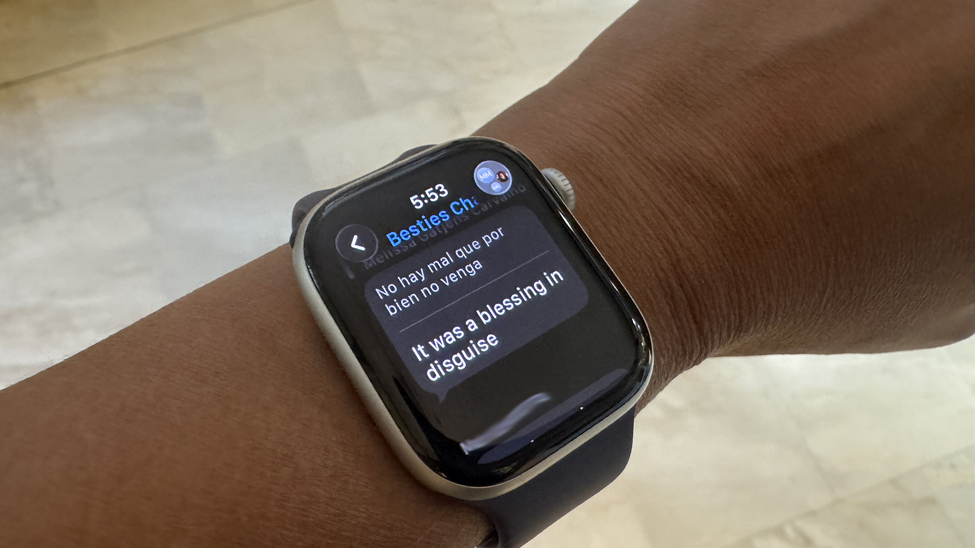 An Apple Watch Series 11 showing an iMessage translated from Spanish to English.