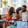 Smiling pregnant woman getting presents at baby shower. Happy mother to be receiving gifts from friends at baby shower party.