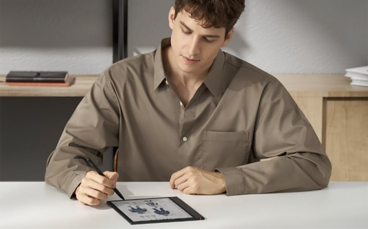 A man writing on the Boox Note Air 4 E Ink tablet.