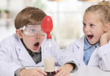 Two kids playing with the Brainstorm Chemistry Kit.