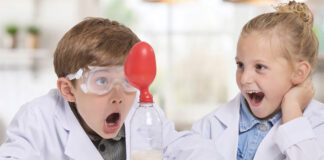 Two kids playing with the Brainstorm Chemistry Kit.