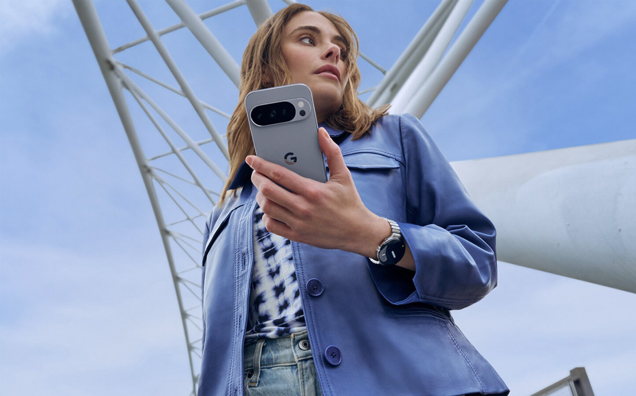A woman holding a Google Pixel 10 Pro phone outside.