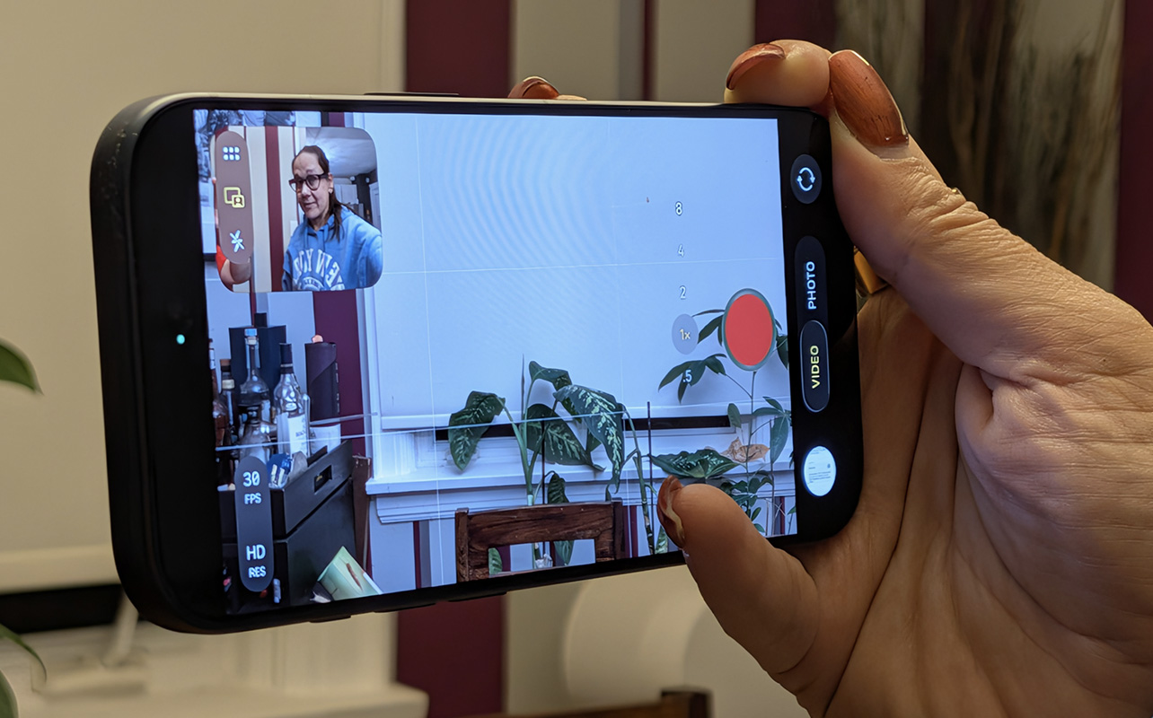 An iPhone capturing a video with a Dual Capture window on the top, left corner.