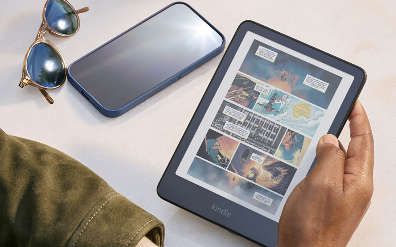 A hand holding a Kindle Colorsoft with a comic book on it.