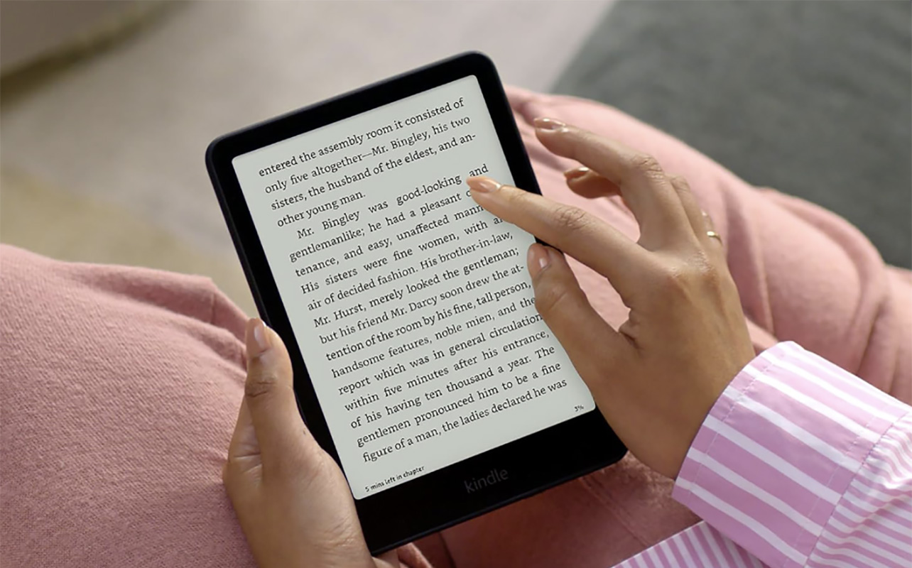 A hand touching text on a Kindle Paperwhite eReader.