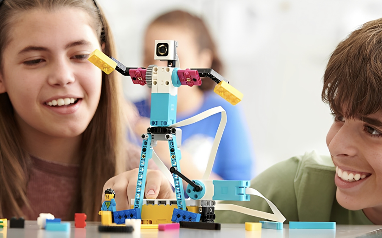 Two kids playing with a built robot.