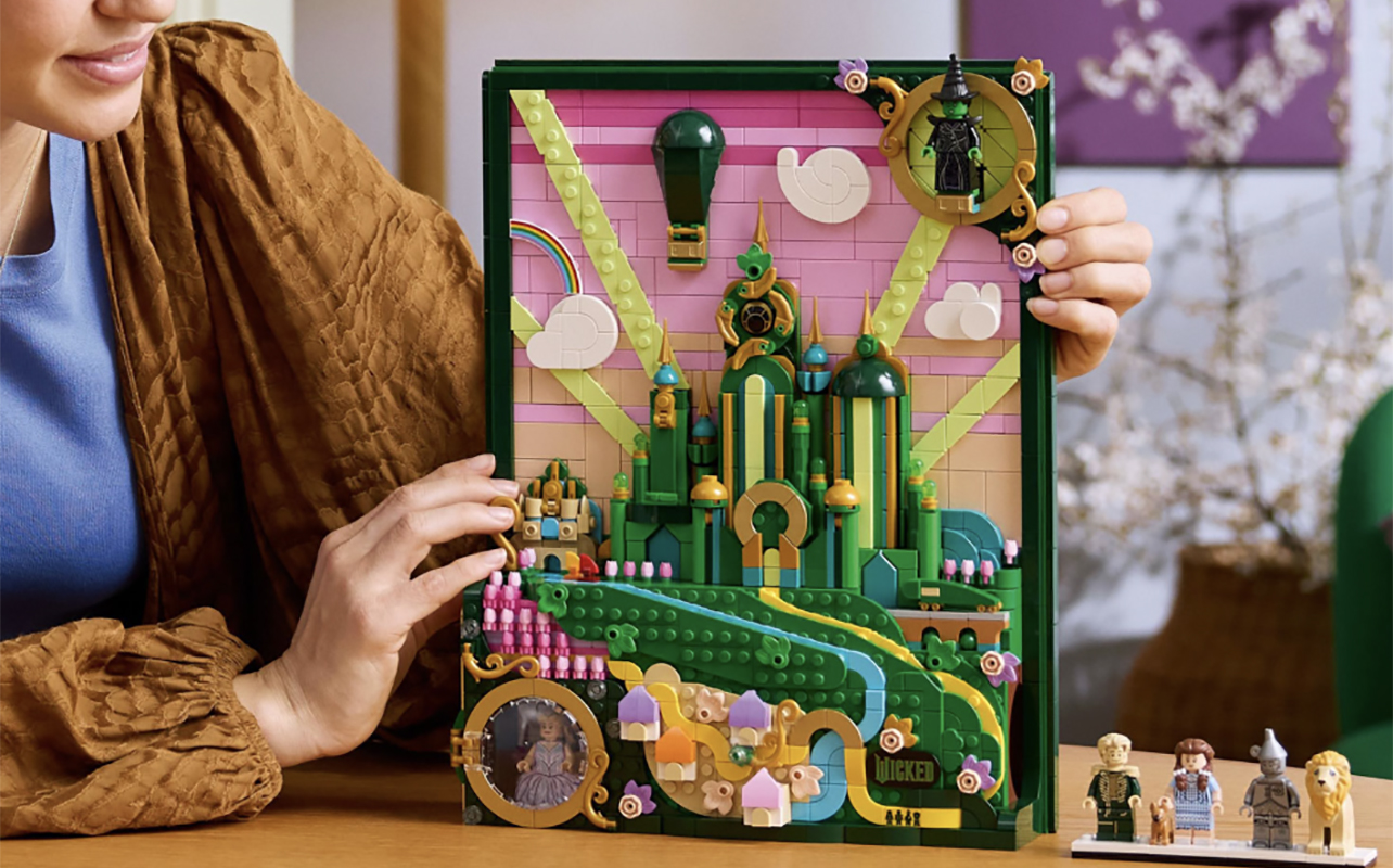 A young girl holding the LEGO Wicked wall art set.