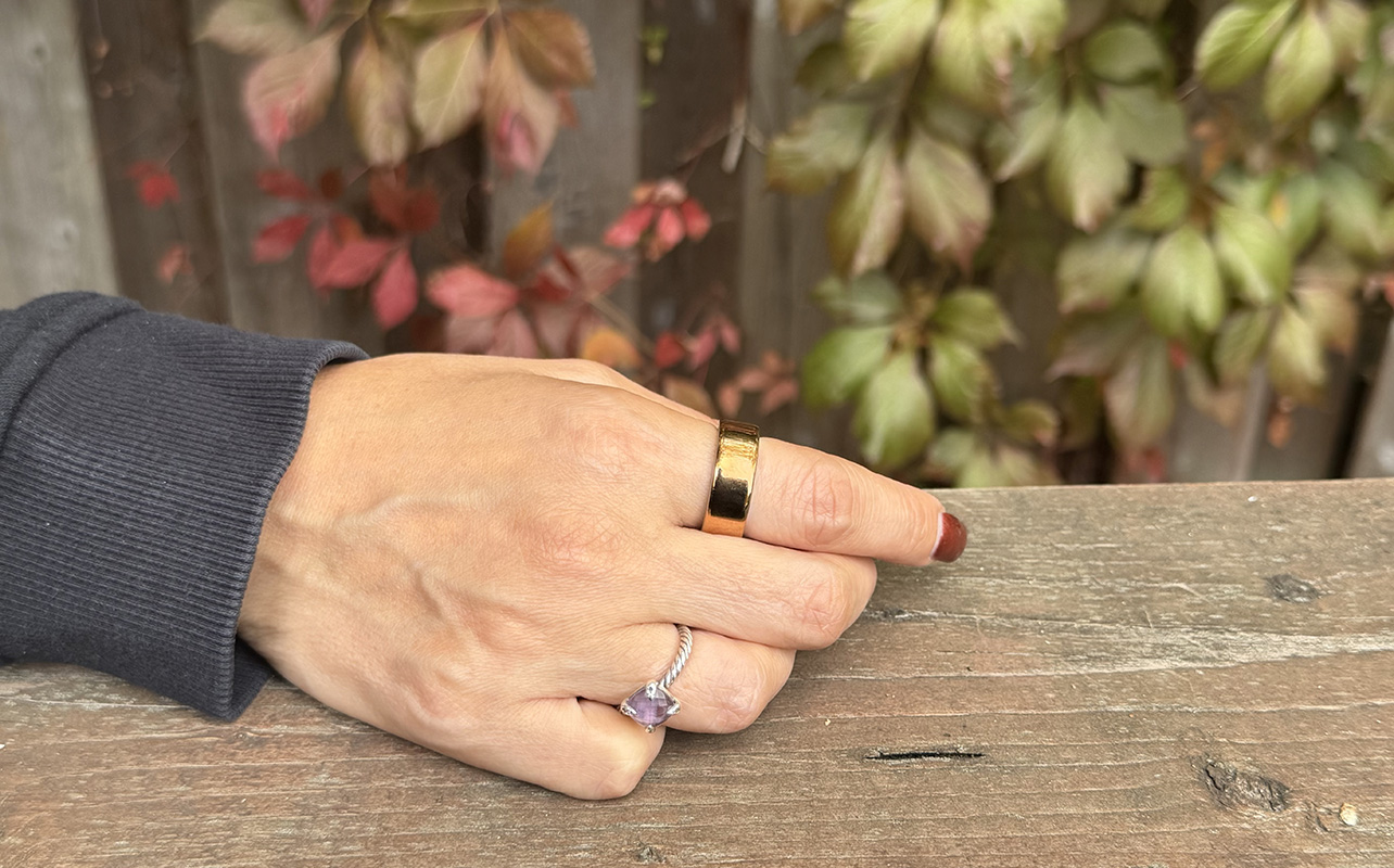A hand resting on a ledge wearing the Oura Ring 4.