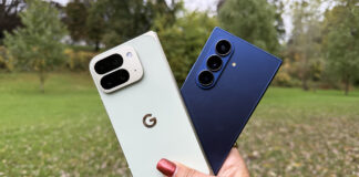 A hand holding the Google Pixel 10 Pro Fold and Samsung Galaxy Z Fold 7 outside.