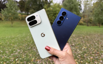 A hand holding the Google Pixel 10 Pro Fold and Samsung Galaxy Z Fold 7 outside.
