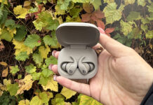 Powerfits Fit earbuds in case open in front of Fall leaves.
