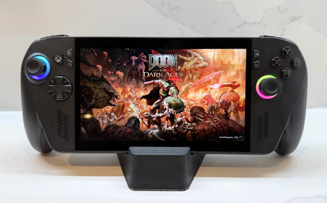 The ASUS ROG Xbox Ally X, sits on a counter with Doom The Dark Ages title screen on display.