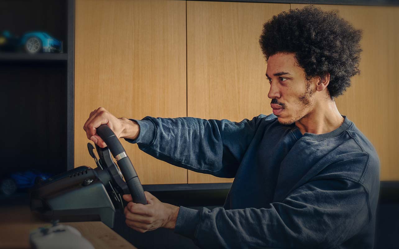 A person gripping their racing steering wheel.