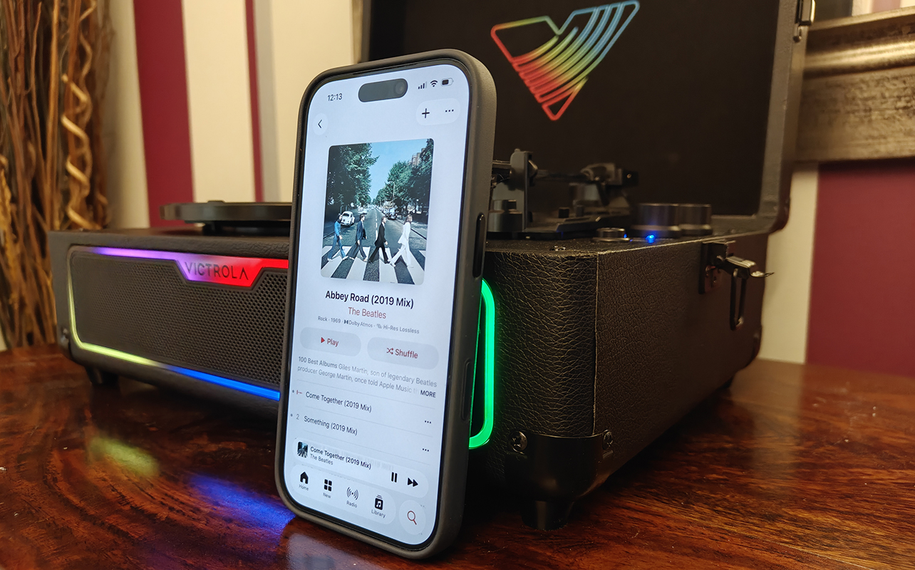 A close up of an iPhone playing Apple Music on the Victrola Journey Glow record player.