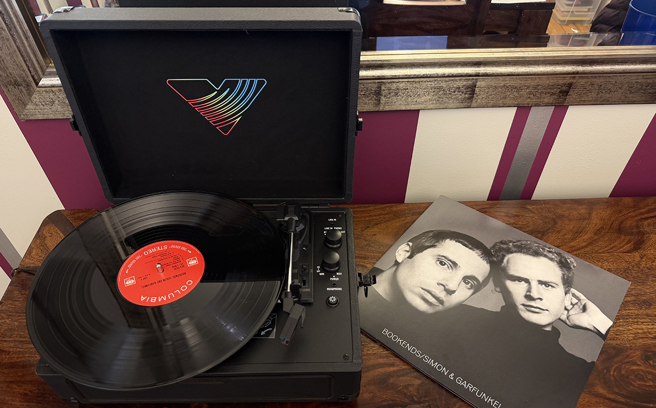 Victrola Journey Glow record player with a record and its sleeve.