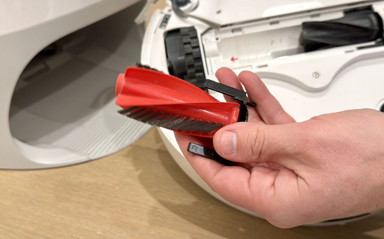 The Roborock Qrevo Curv Robot Vacuum one half of its duo brush head removed.
