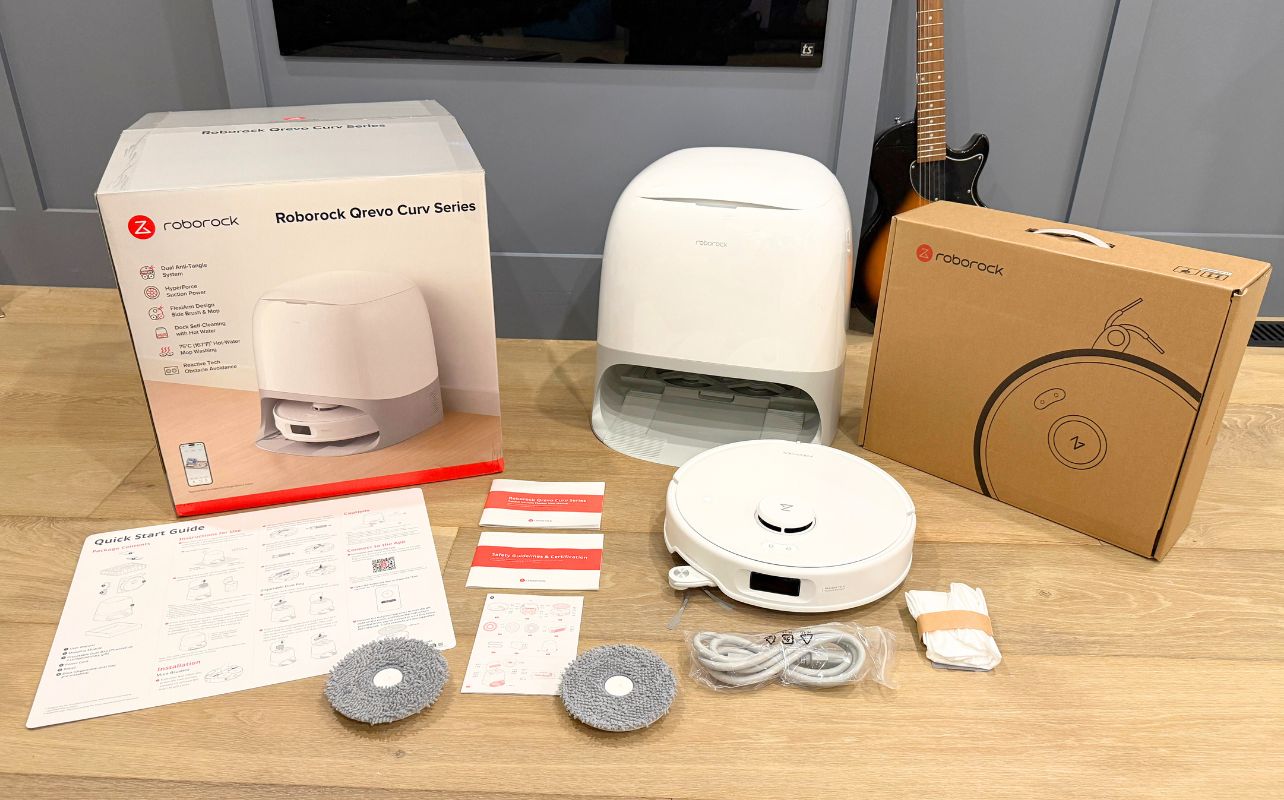 The Roborock Qrevo Curv Robot Vacuum is laid out with all its components visible, completely unboxed.
