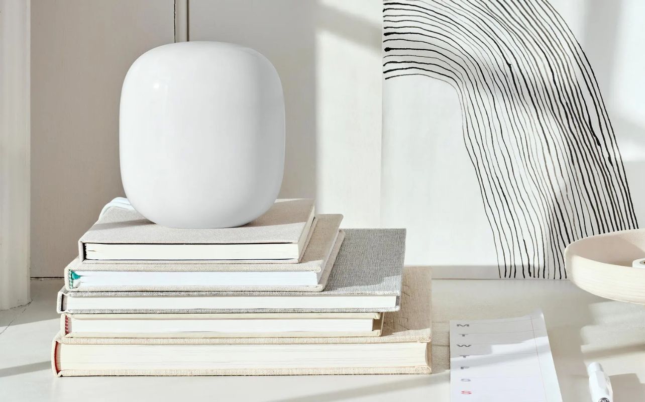 The Nest Wi-Fi Pro sits a top books with a stylized background.