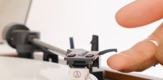 A finger on the stylus of the Electrohome Montrose Audio Technica turntable.