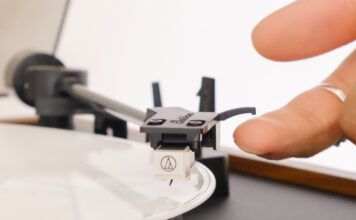 A finger on the stylus of the Electrohome Montrose Audio Technica turntable.