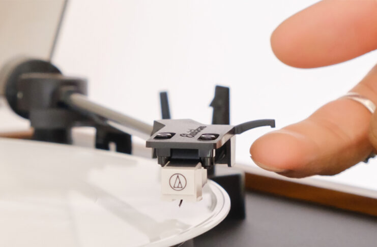 A finger on the stylus of the Electrohome Montrose Audio Technica turntable.