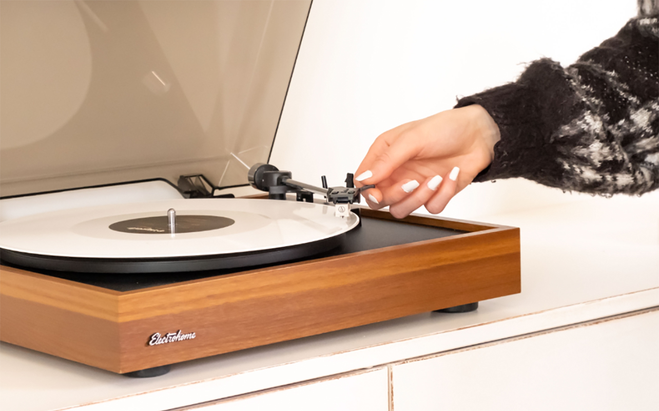 Une main pose le diamant sur le tourne-disque Montrose d'Electrohome. 