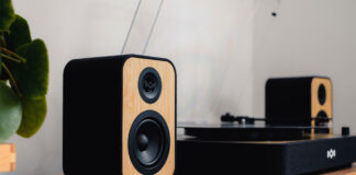 House of Marley Stir It Up Revolution turntable on a stand with speakers.