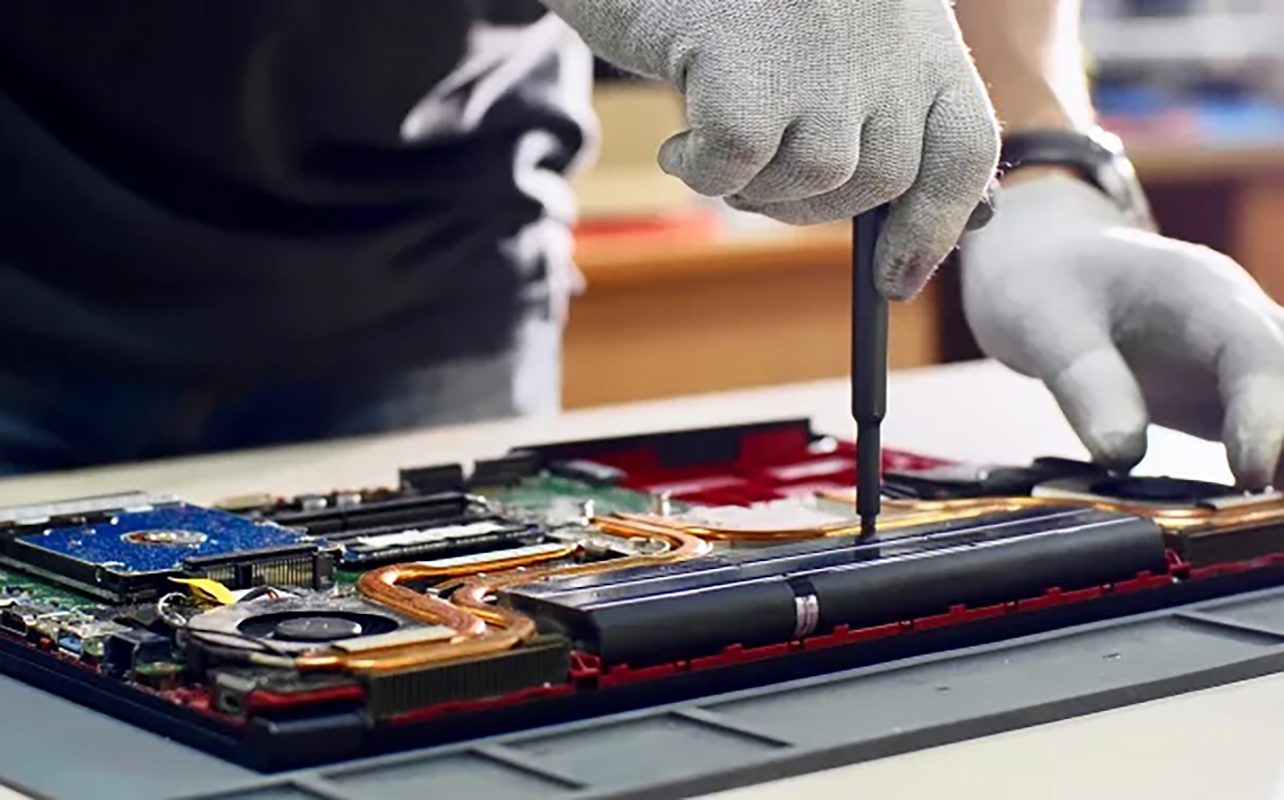 Image shows hands of a technician while restoring a laptop