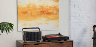JBL USB Bluetooth turntable set up on furniture beside a speaker.