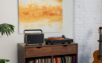 JBL USB Bluetooth turntable set up on furniture beside a speaker.