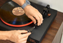 How to replace a needle on a record player A man fiddling with the stylus on a JBL turntable.