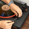 How to replace a needle on a record player A man fiddling with the stylus on a JBL turntable.