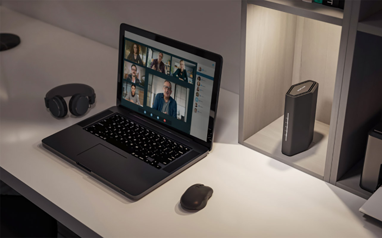 Netgear Nighthawk BE3600 router with a laptop.