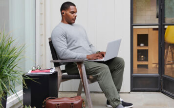 A man sitting back on his laptop.