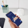 A hand holding a phone with the eero 6 mesh router app.