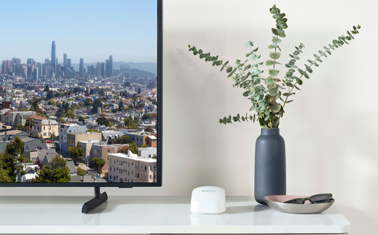 An Eero 6 router on a table beside a TV.