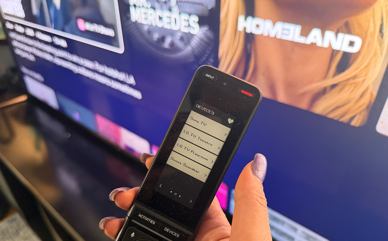 A One For All Smart Touch Pro remote in a living room in front of a TV