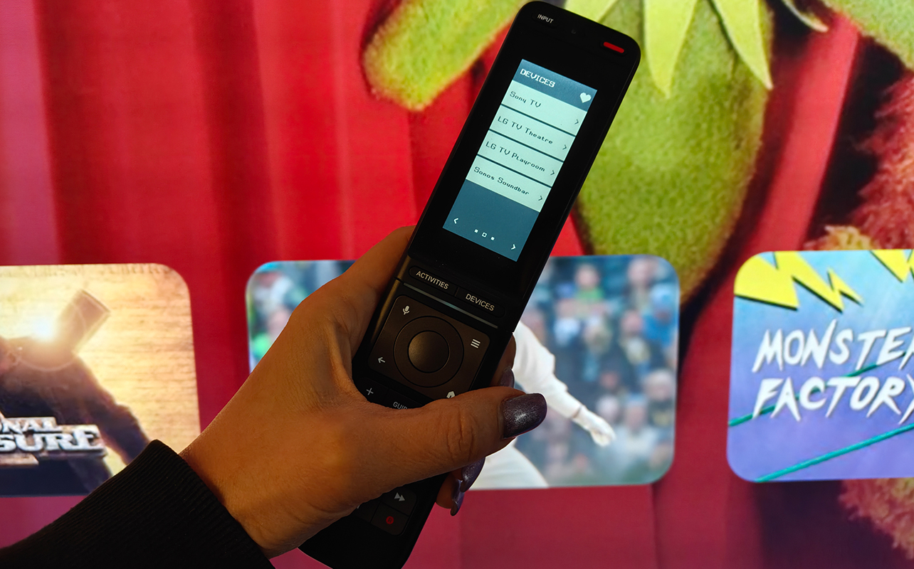 One For All Smart Pro Touch remote in front of a TV.