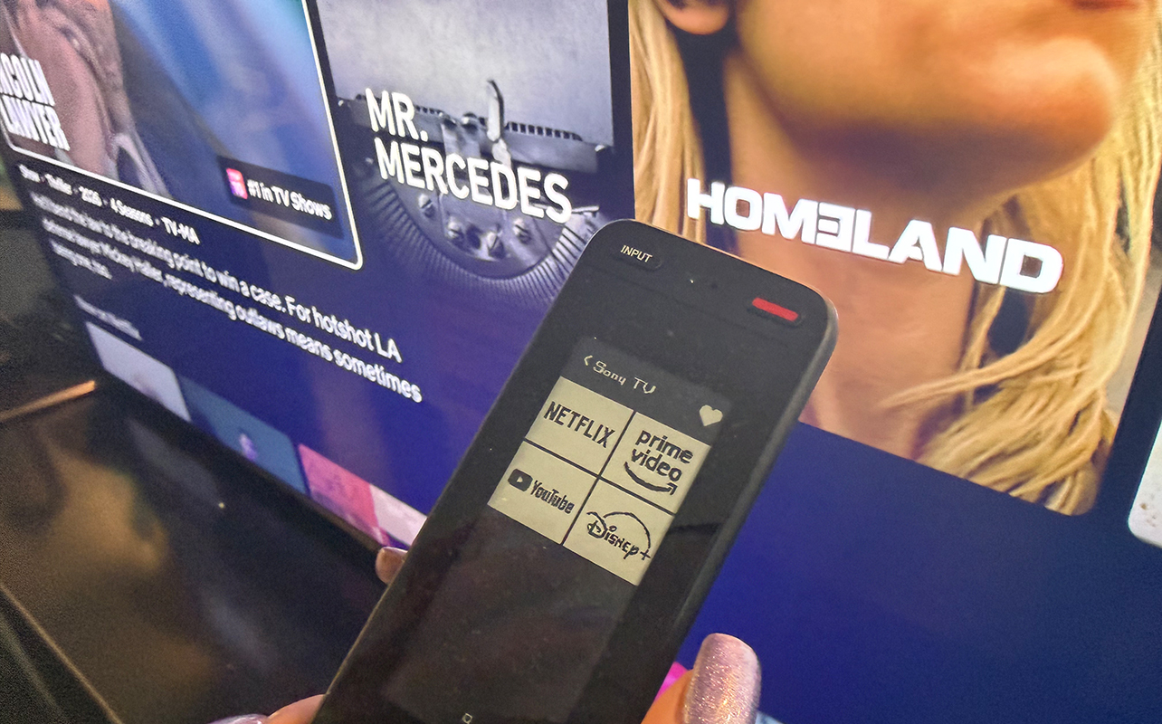 One for All Smart Touch Pro remote in front of a TV.