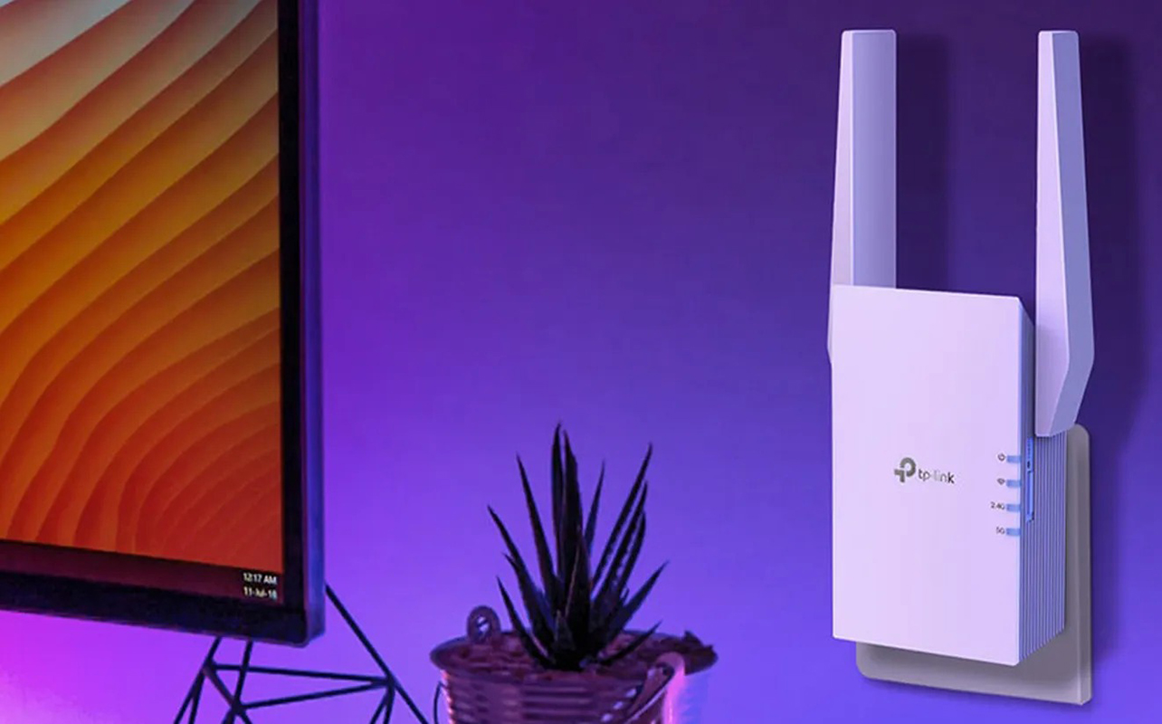A TP-Link RE705X range extended mounted on the wall beside a TV.