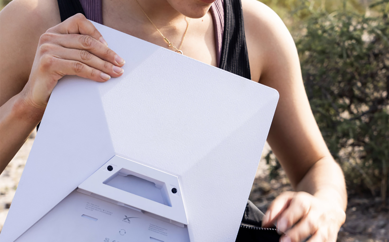 A woman putting a Starlink Mini Kit in a bag.