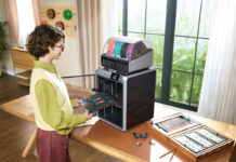 Woman using a 3D printer on a table at home.